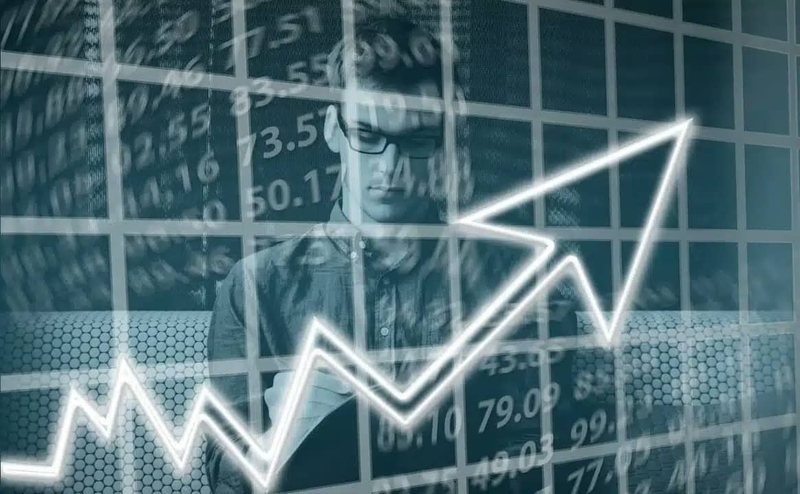 Homem com números e gráfico com seta crescente
